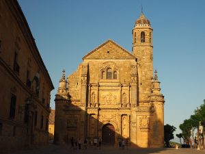 A view of the front of El Salvador Chapel in Ubeda, with detailed sculpture on the facade, and a tall tower.