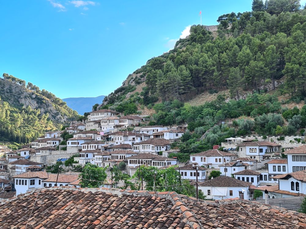 Albania travel tip: visit Berat, a pretty scattering of white houses with red roofs nestled next to a mountain.