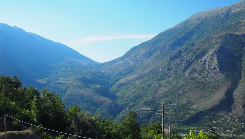 A big view down a valley, with high mountains into the distance on either side.