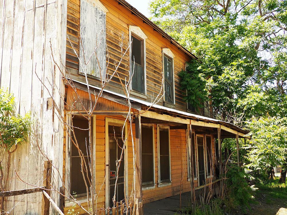 Seen from the side, a residence that must have been fairly substantial: two stories, a roof over the front sidewalk/porch. At Chinese Camp ghost town in California.