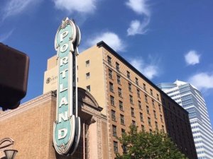 A multi-story building in downtown Portland, with a vertical sign that says "Portland"