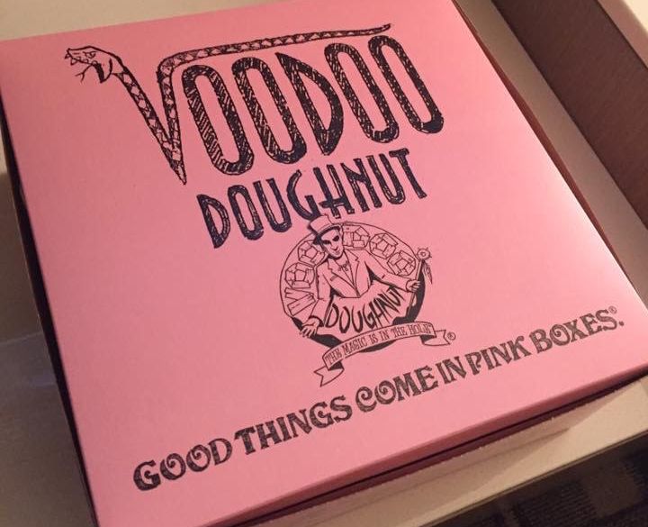 A pink box printed with the words "Voodoo Doughnut: Good things come in pink boxes."