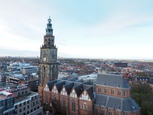 View of the church with its gothic arches and the tall tower at one end, the city spreading out around it.