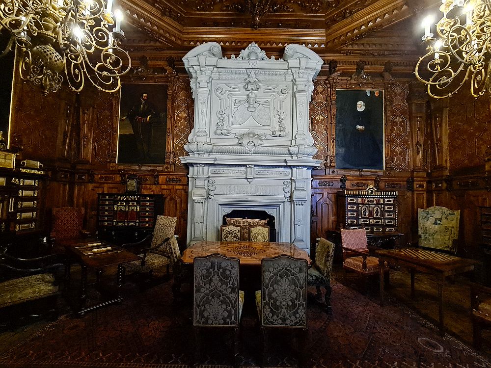 One of the rooms with a huge white marble fireplace, carved wood panelling, and tables set with games like chess and backgammon.