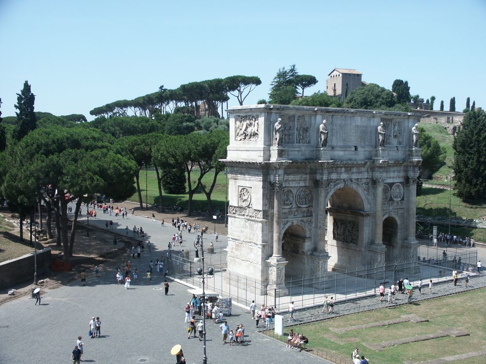 Seen from a high angle, it is a large square structure with a large central arch and a smaller arch on either side of the central one. It is covered with carved bas-reliefs. Tourists at the base give an indication of how large it is.