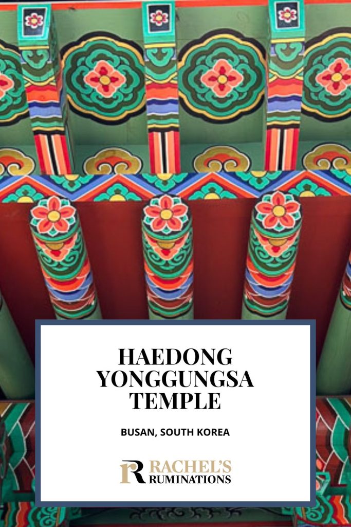 Text: Haedong Yonggungsa Temple, Busan, South Korea (and the Rachel's Ruminations logo). Image: bright and colorful painted detail under the eaves of the temple.