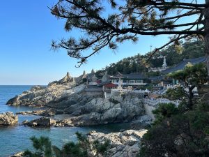 View of most of the temple buildings perched on rocky outcrops above the sea.