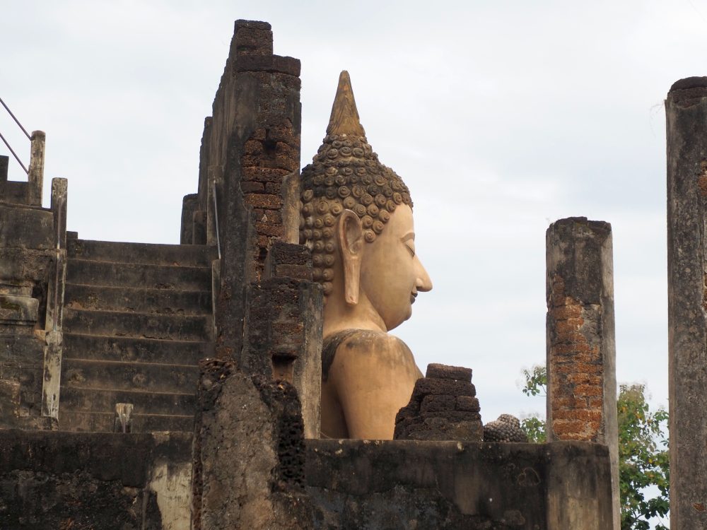 Seen from the side, the Buddha figure's shoulders and head stick up above the structures around it.