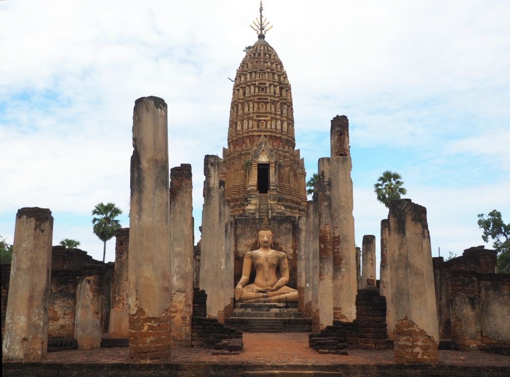 Rows of columns frame a seated Buddha with, centered behind the Buddha, a prang.