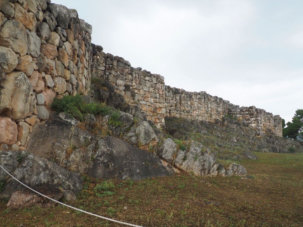 Large stone walls looming above the camera and stretching into the distance.