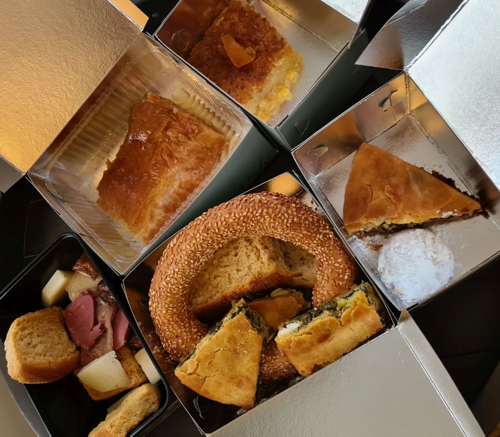 Five boxes with assorted breads and pastries.