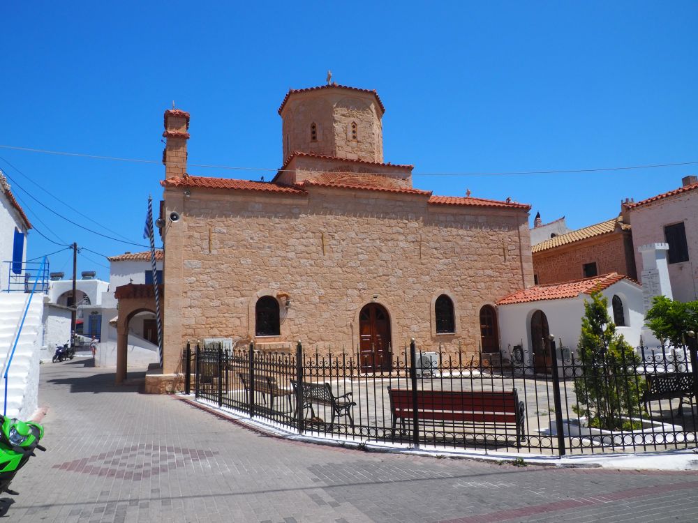 A rather simple stone church with an arched doorway and a few arched windows but no adornment. the dome on top is six-sided and also stone.