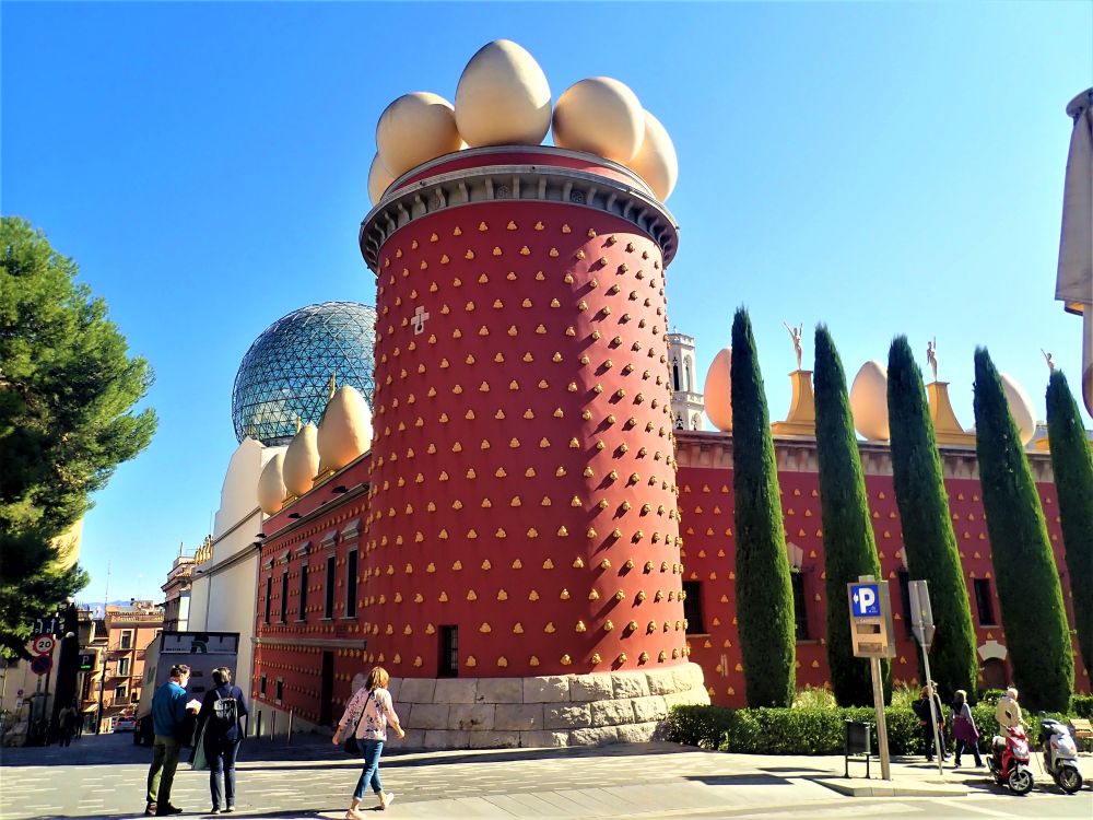 A red building - this photo only shows one corner, where a round tower stands, like the guard tower of a castle, but it it topped with huge egg-shaped forms rather than crenellations.