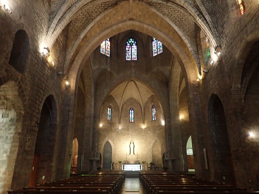 Looking toward the altar of the church, a romanesque interior, with an arched ceiling.