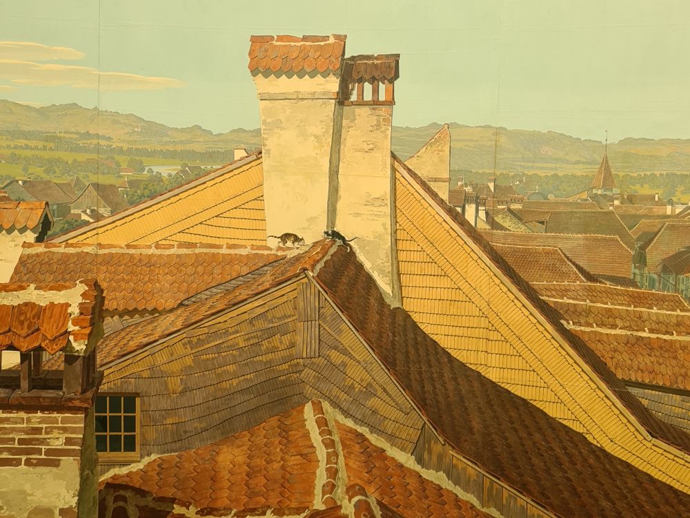 Old red-tiled rooftops, with two cats arching their backs and hissing at each other on one of the roofs.