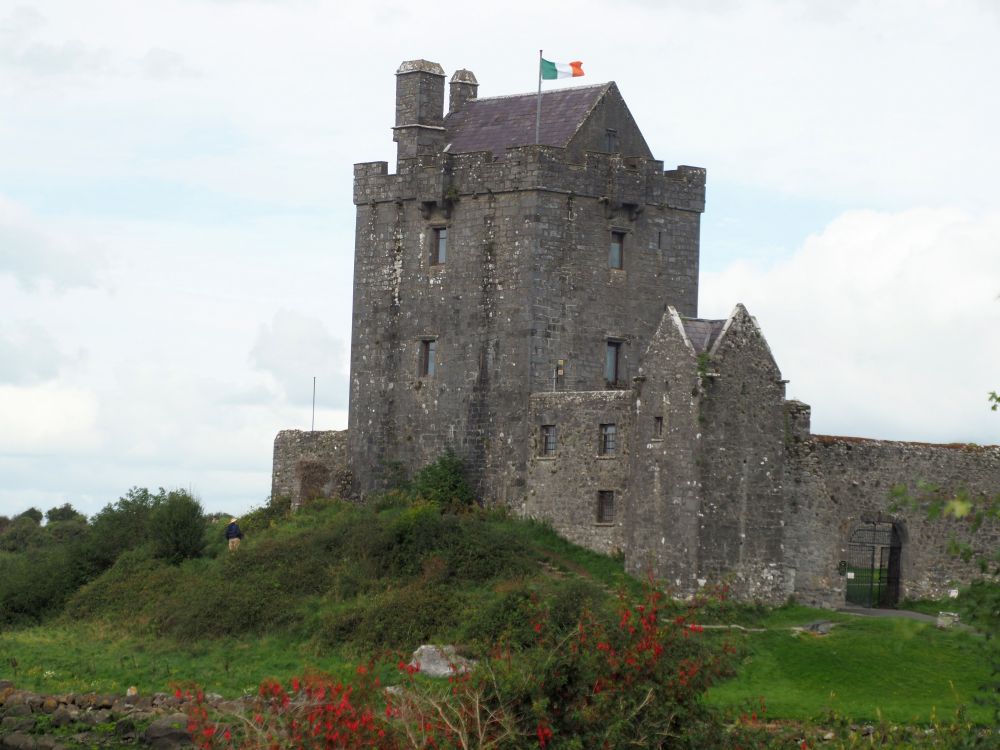 Tall square tower with a smaller building attached to its ground floor.