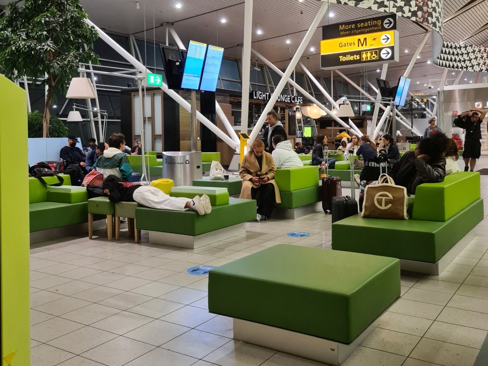 Green square benches, people sitting or lying on them.