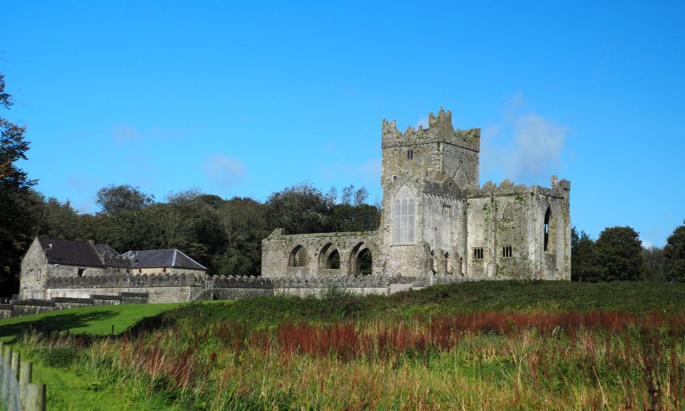 A ruin of an elegant gothic church, with a tall square tower in its center.