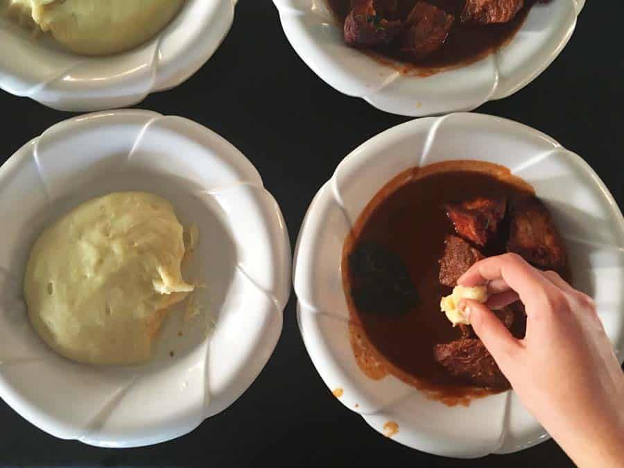 Bowls of food seen from above: stew on the right, some sort of starch on the left.