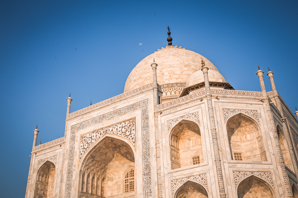 Looking up at the mausoleum bulding: white marble, ornately decorated.