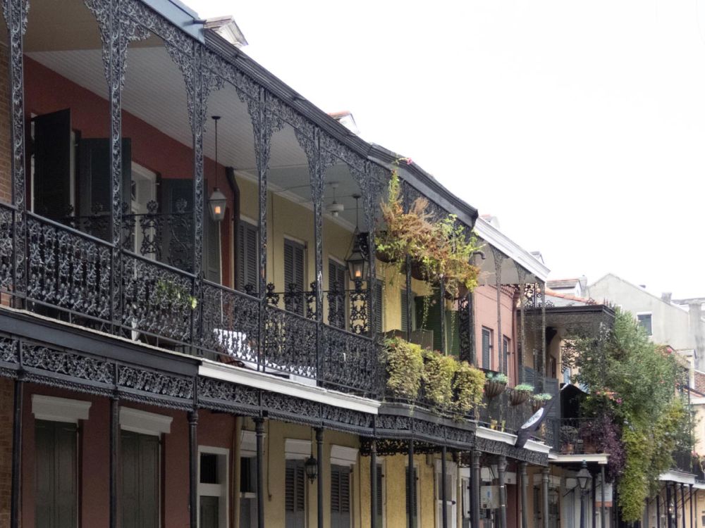 A row of French quarter buildings with lacy wrought-iron balconies.