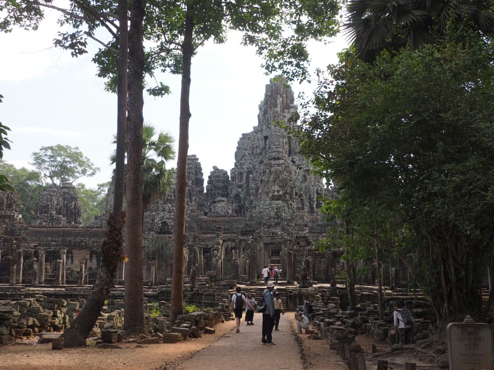 A pyramid-shaped temple as seen down a walking path.