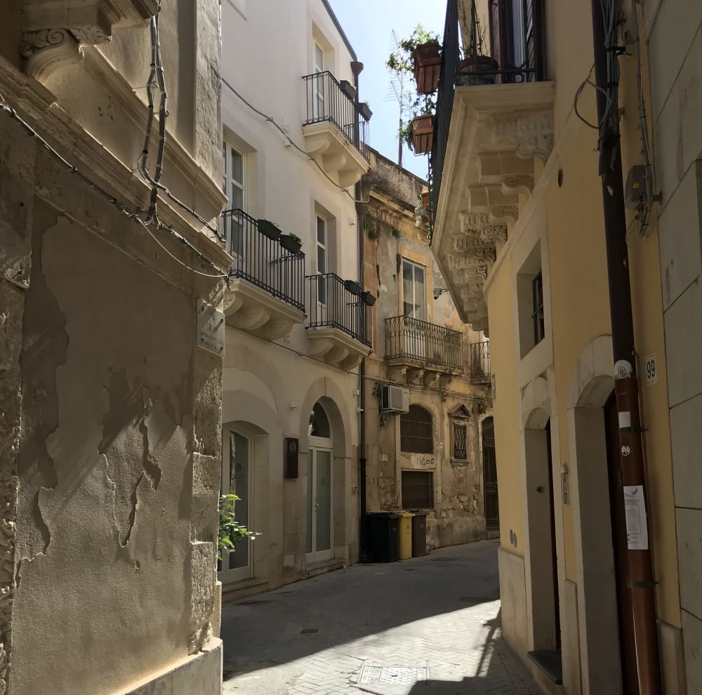 A narrow and bendy street with houses crowding it.