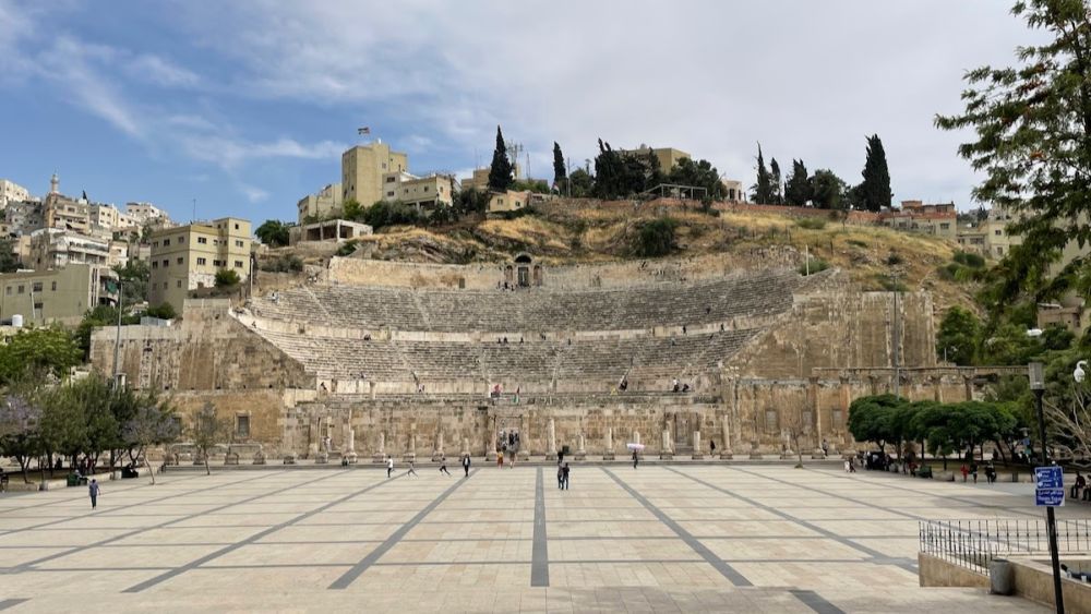 A ruin of an amphitheater as seen across a large plaza in Amman.