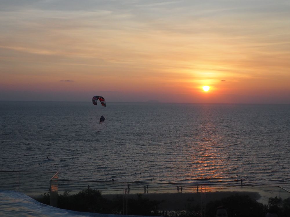 Sunset over the sea with a kitesurfer.