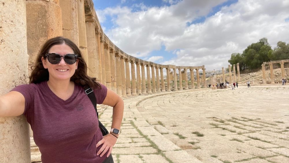 Cat standing in front of a long curved row of pilars at Jerash, Jordan.