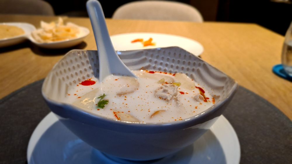 A bowl of coconut soup with chicken.