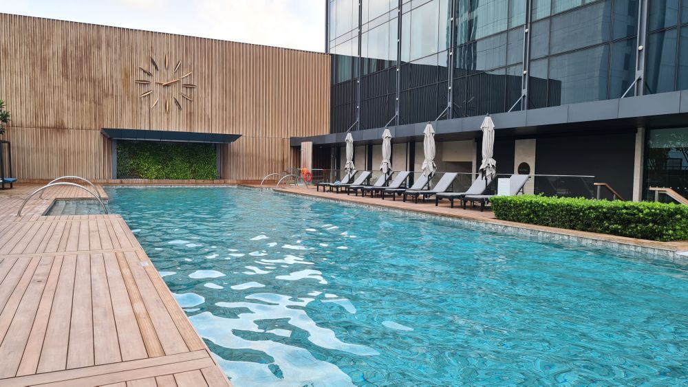 A large blue pool edged with wood and marble.