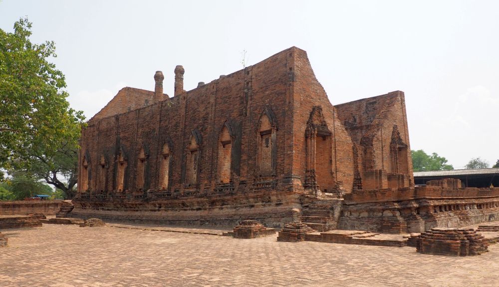 A large rectangular building of brick, with arched windows along its side.