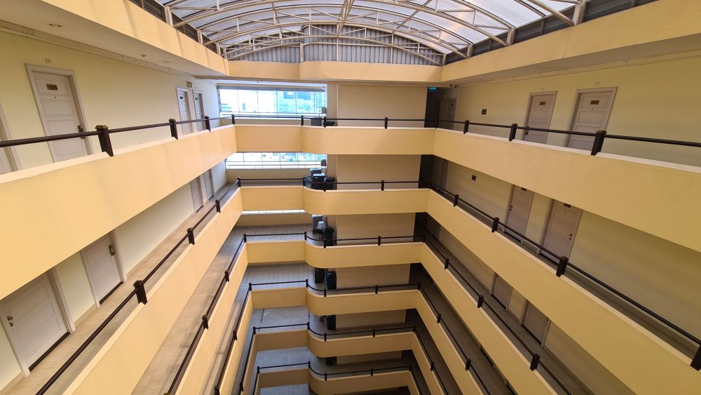 Atrium with a glass roof and walkways all around each floor.