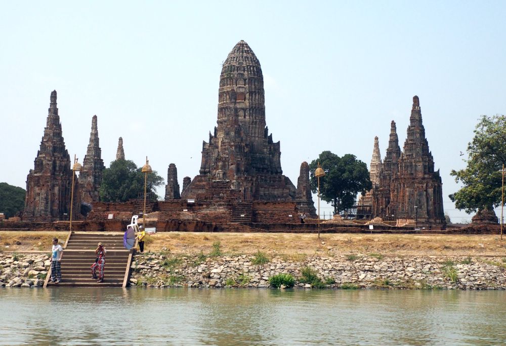 A tall ornate prang in the center, and two rows of smaller pointed stupas on either side.