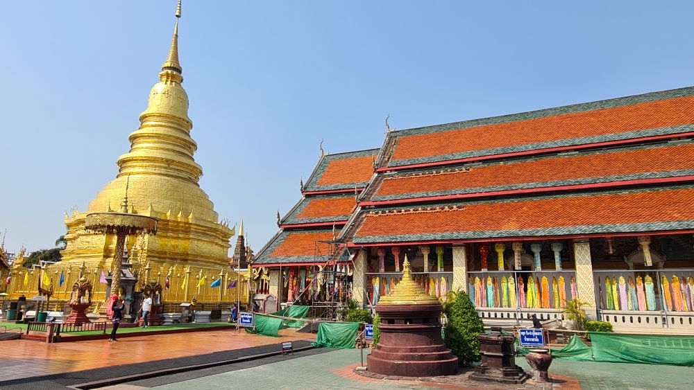 A golden pagoda next to an ornate temple.