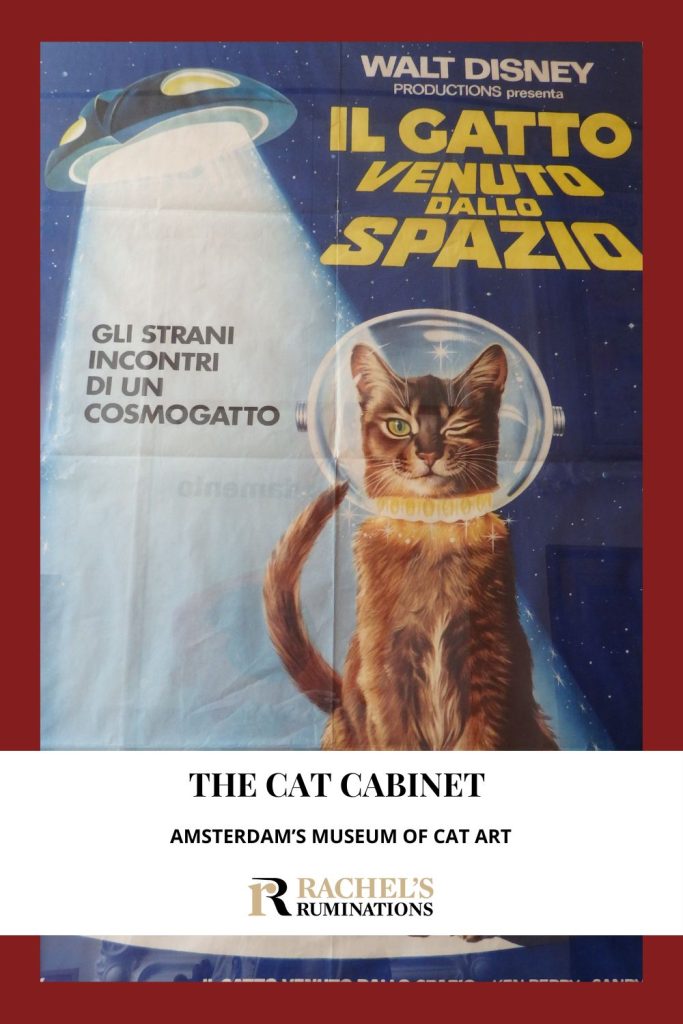 Text: The Cat Cabinet: Amsterdam's Museum of Cat Art. Image: a movie poster showing a cat in a space helmet with a flying saucer behind it.