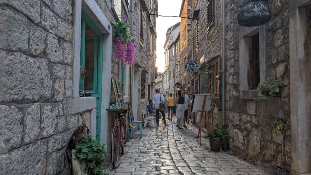 A narrow cobbled street with stone houses on either side.