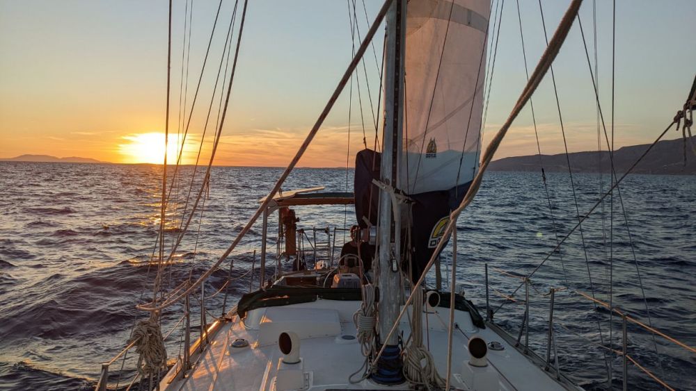 View looking forward on the boat toward a sunset over the sea.