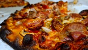 A pizza with mushrooms, edged charred.