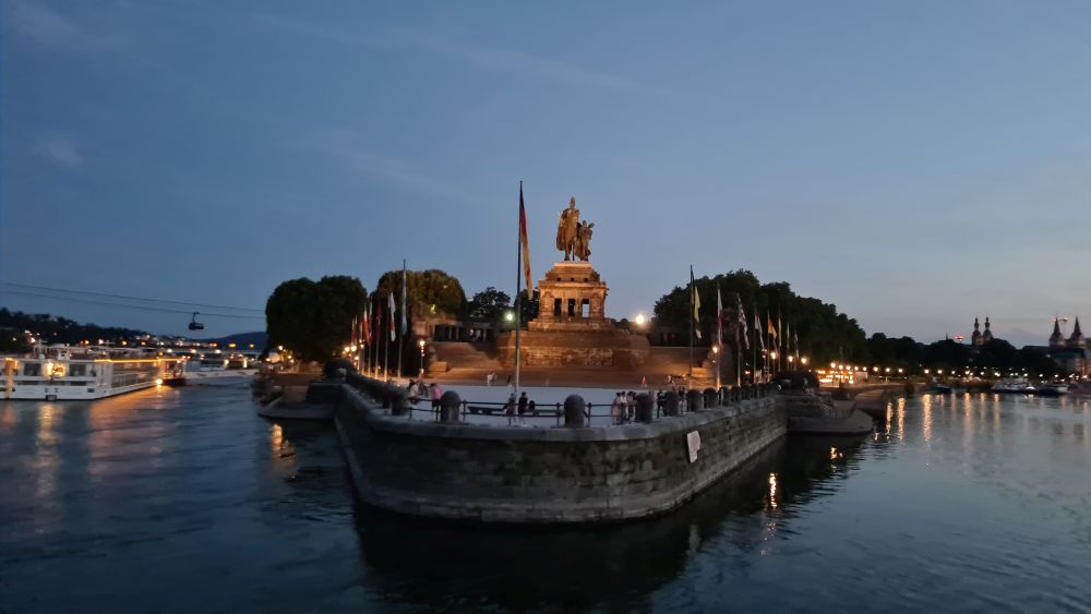 A point of land seen from the water, with a huge high statue of a man on a horse.