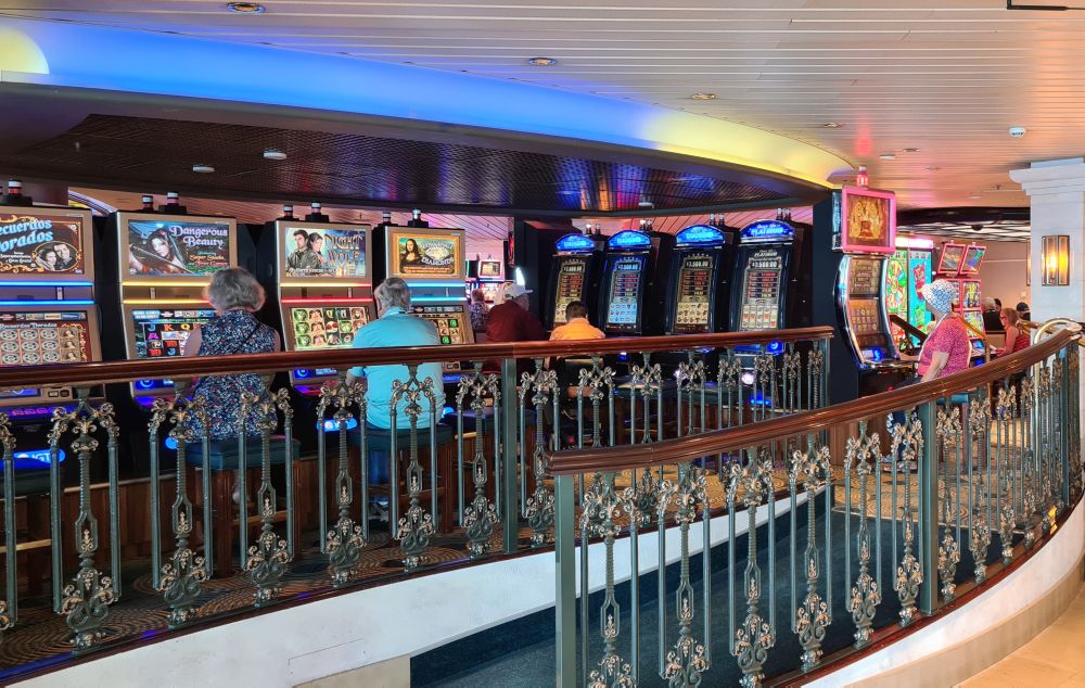 A row of slot machines, with more slot machines visible in the distance.