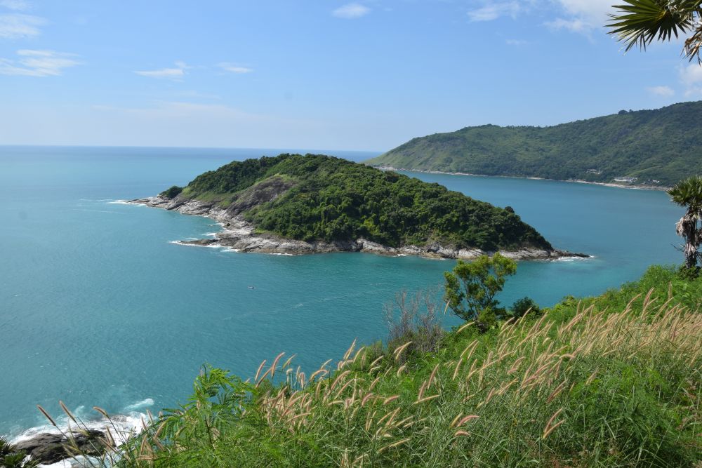 A view from a high point over a blue sea with a green island.