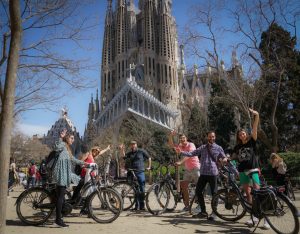 People pose on their bikes in front of the La Sagrada Familia cathedral in Barcelona.