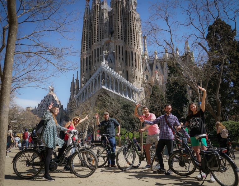 People pose on their bikes in front of the La Sagrada Familia cathedral in Barcelona.