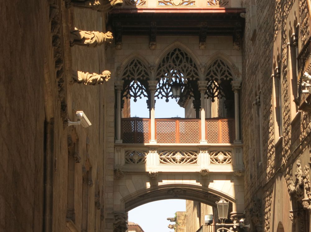 An archway over a street that carries a portico of 3 lacy arches.