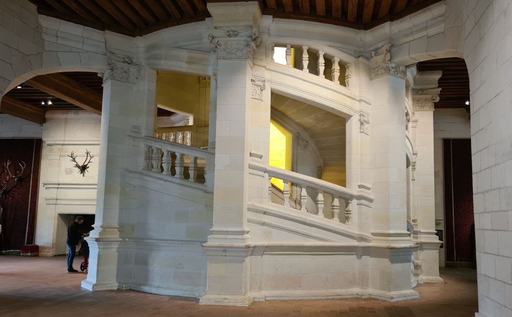 The central double stairway: stone, circular, with light shining the central well.