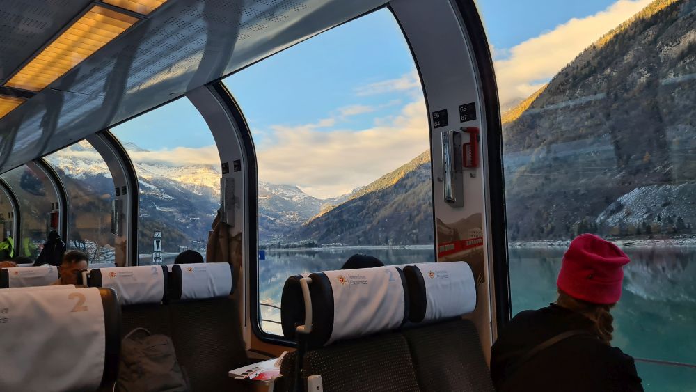 Interior of the Bernina Express, with big mountain views outside.