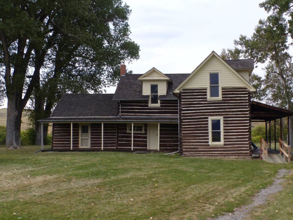 A neat two-story house with a veranda across part of it.