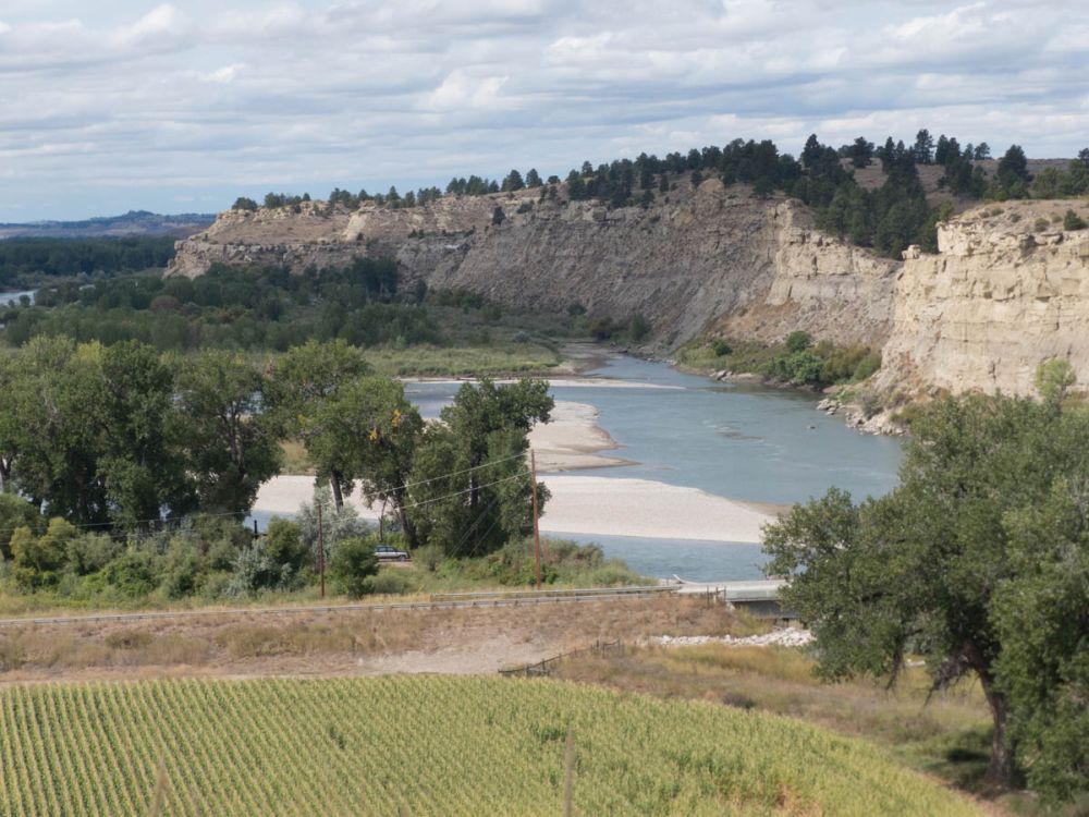 A curving river with cliffs along it on one side.